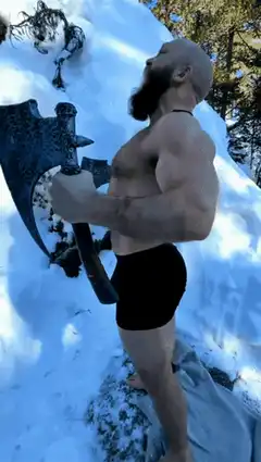 Bearded man jumps off snowy cliff with axe