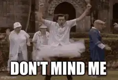 Man in tutu dancing with arms raised