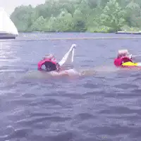 Two people in life jackets floating on a lake