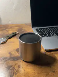 Metal cup on wooden desk