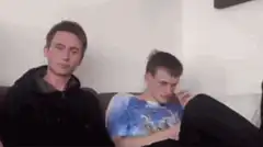 Two guys on couch, one looks away