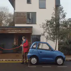 Man pulling tiny car with red rope