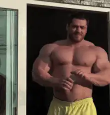 Muscular man flexing in yellow shorts