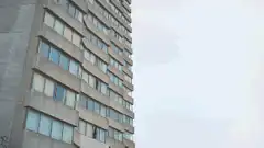 Person putting on a white t-shirt