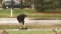 Man shoveling water from street