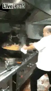 Chef tossing food in flaming wok
