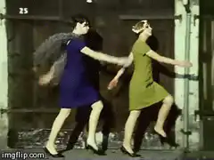 Two women in 60s dresses dancing