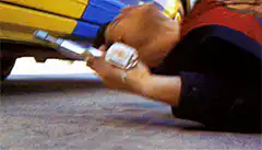 Man shooting taxi tire with shotgun