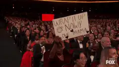 Woman holds up sign at awards show