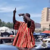 Man in red striped robe dancing on car
