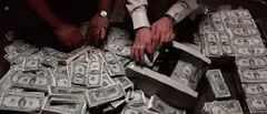 Hands counting stacks of hundred dollar bills