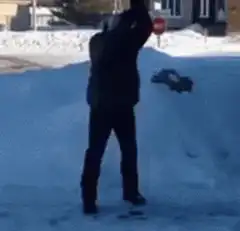 Man shoveling snow slips and drops shovel