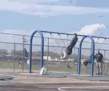 man swings on monkey bars