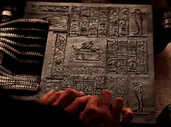 Hands on ancient hieroglyphic stone tablet