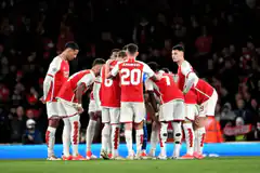 Arsenal players huddle on pitch