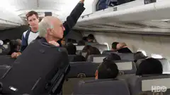 Larry David puts suitcase in overhead bin
