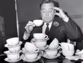 Man drinking tea surrounded by cups