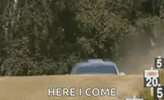 Rally car speeding past with HERE I COME text