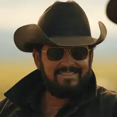Man in cowboy hat and sunglasses smiling