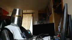 Knight in armor typing on computer