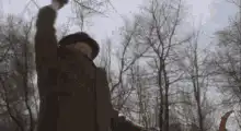 Old man in hat and coat dancing