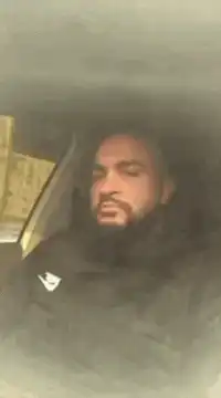 Man in car pointing and nodding