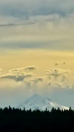 snowy mountain under cloudy sky