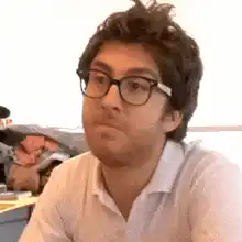Man with glasses pursing lips