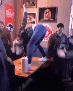 Woman twerking on a table with a rat on her back