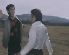 Two men fighting in a field
