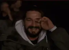Shia LaBeouf laughing and facepalming