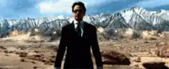 Tony Stark stands in desert with explosions