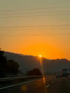 sunset over highway with mountains