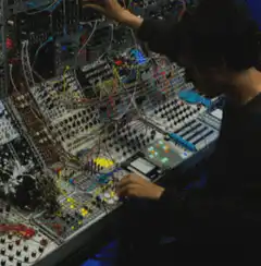 Man playing modular synthesizer