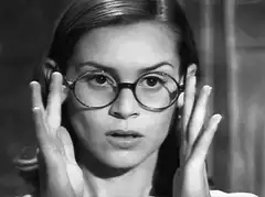woman lowers glasses to look over them