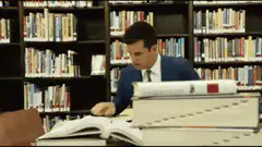 Man uses microscope and abacus in library