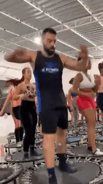 Man jumping on trampoline in gym
