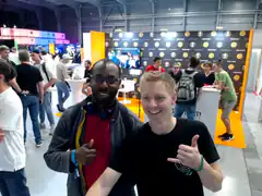 Two men giving thumbs up at a tech conference