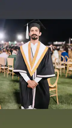Graduate in cap and gown at night ceremony