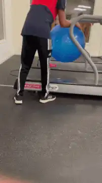 guy rolls exercise ball under treadmill
