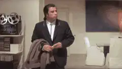 John Travolta holding a coat and gesturing