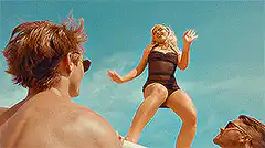 Woman in swimsuit dancing on beach