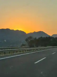 sunset over mountains from highway