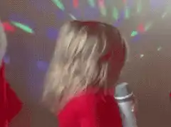 Baby singing into microphone with disco lights