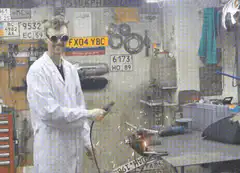 Man in lab coat grinds metal with sparks