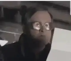 Man with glasses eyes widen in shock