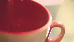 Coffee being poured into a red mug