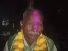 Old man with pink tilak and flower garland