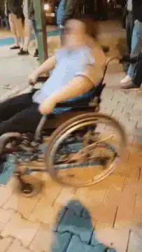person in wheelchair rolling backwards