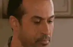 Man looks down then smirks